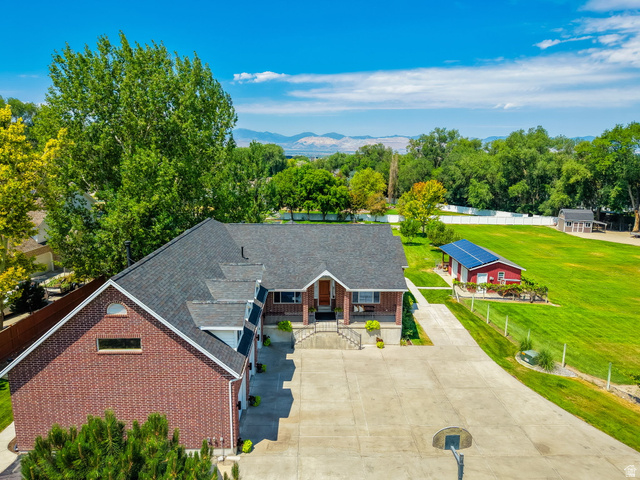 13658 South Fort Street Draper, UT 84020 - Photo 6 of 87 Expansive property featuring a brick and siding residence with a dark shingle roof, a large concrete driveway, and a red accessory building with solar panels