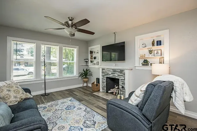 a living room with furniture a flat screen tv and a fireplace