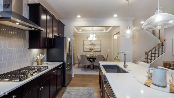 a kitchen with stainless steel appliances granite countertop a sink a stove and a refrigerator