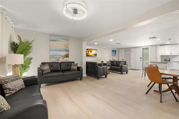a living room with furniture kitchen view and a potted plant