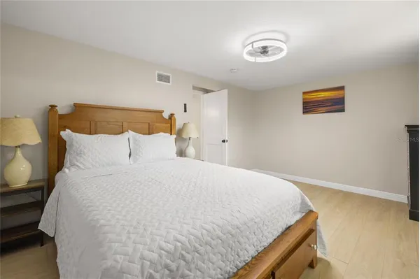 a large bed sitting in a bedroom next to a window