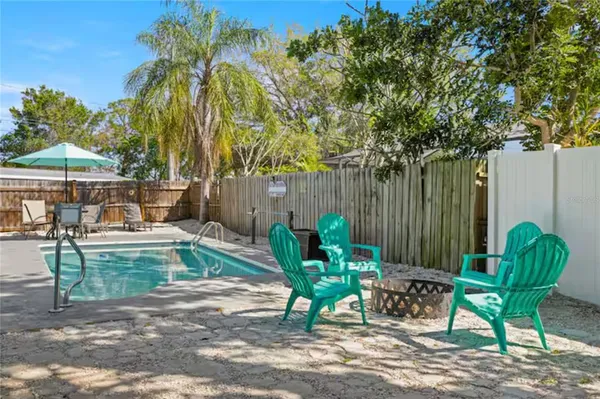 a view of a backyard with chairs potted plants and a fountain