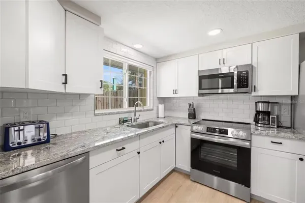 a kitchen with stainless steel appliances granite countertop a sink and a stove