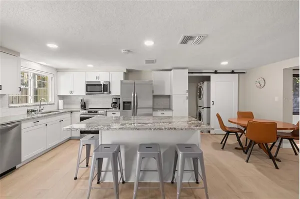 a large kitchen with a table and chairs
