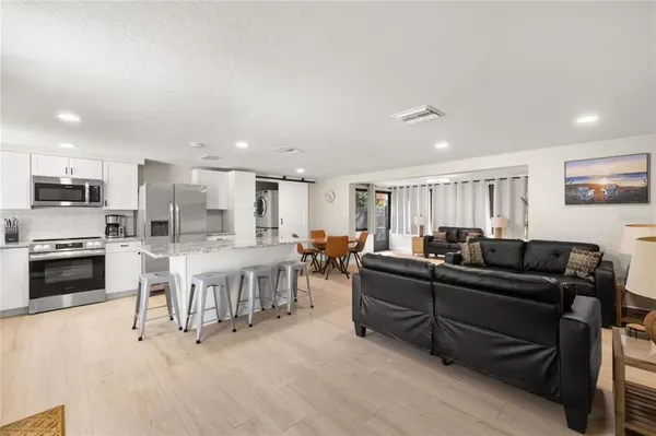 a living room with lots of furniture and kitchen view