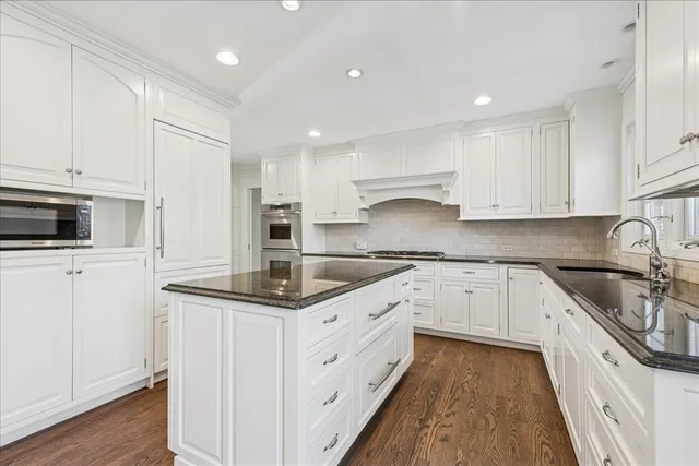 a kitchen with granite countertop white cabinets white stainless steel appliances and sink