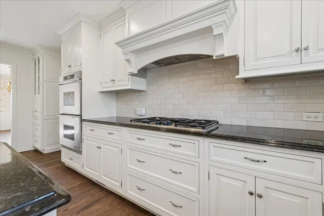 a kitchen with white cabinets and appliances