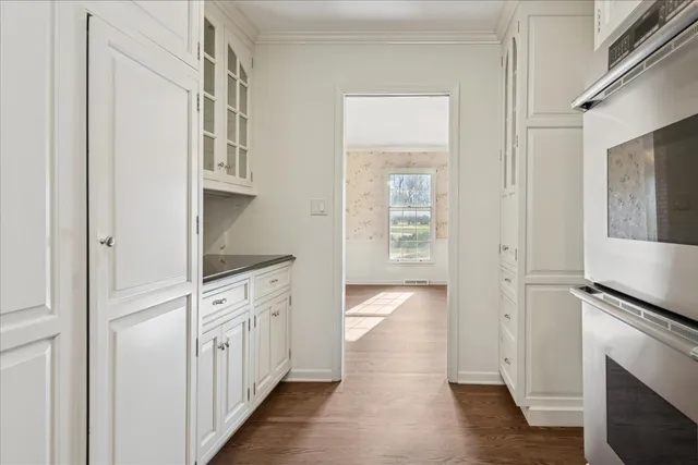 a kitchen with white cabinets and sink