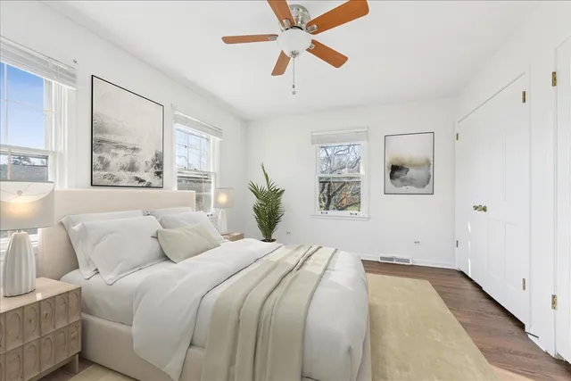 a bedroom with a large bed and a chandelier fan
