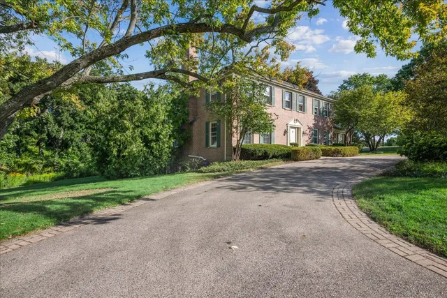 a view of a big building with a big yard and large trees