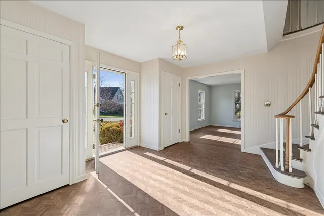 a view of a hallway with wooden floor and staircase