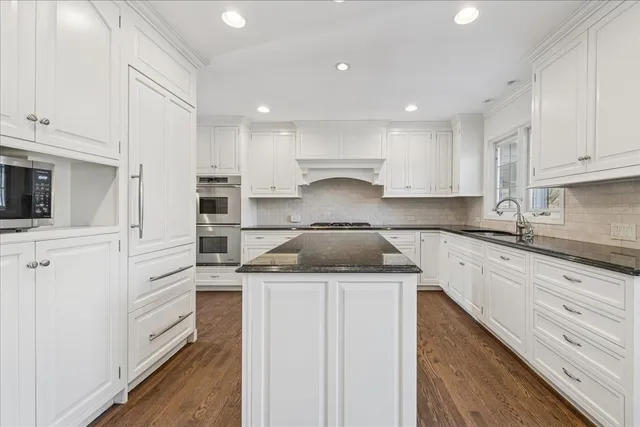 a kitchen with a stove sink and cabinets