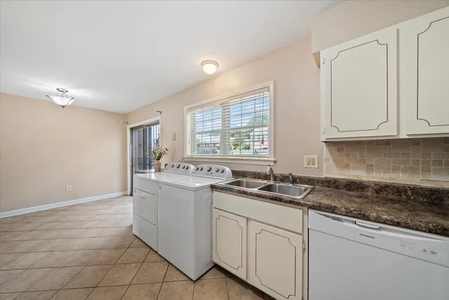 a kitchen with granite countertop white cabinets and white appliances