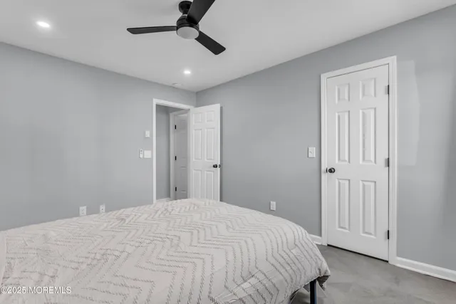 a bedroom with a large bed and chandelier fan