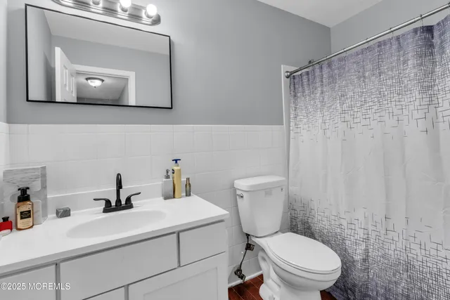 a bathroom with a toilet a sink and mirror