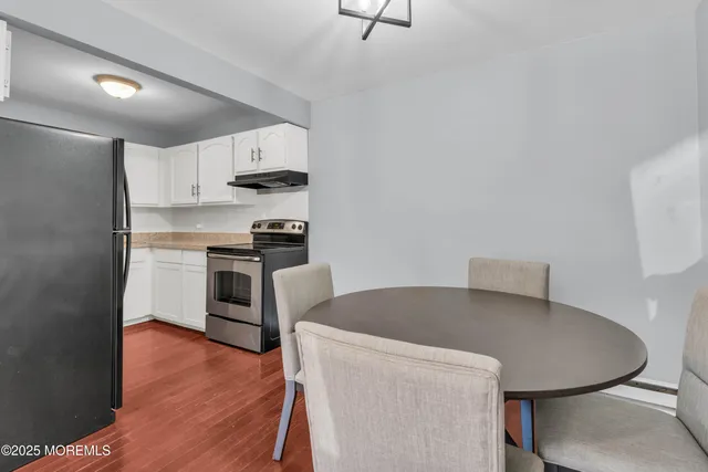 a kitchen with stainless steel appliances a stove a table and chairs