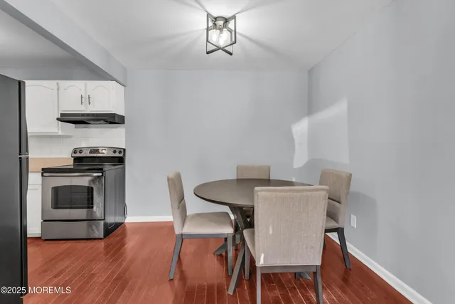 a kitchen with stainless steel appliances a stove a table and chairs
