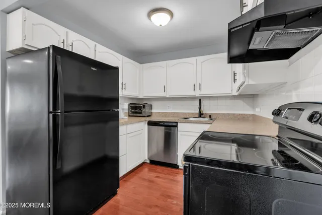 a kitchen with a refrigerator stove and cabinets
