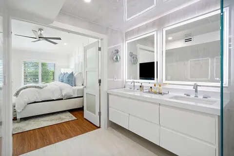 a en suite bathroom with a double vanity sink a mirror and a shower