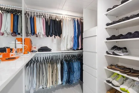 a view of walk in closet with clothes and shoes