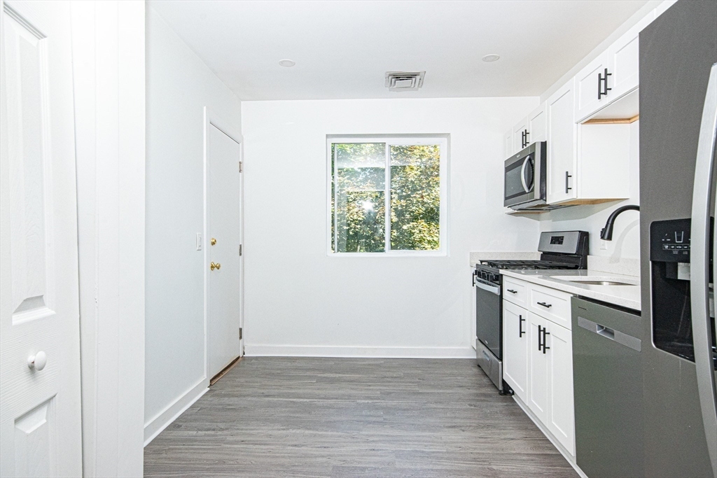 41 Bayberry Drive, Unit 4 Sharon, MA 02067 - Photo 14 of 27 a kitchen with stainless steel appliances granite countertop a stove a sink and a refrigerator