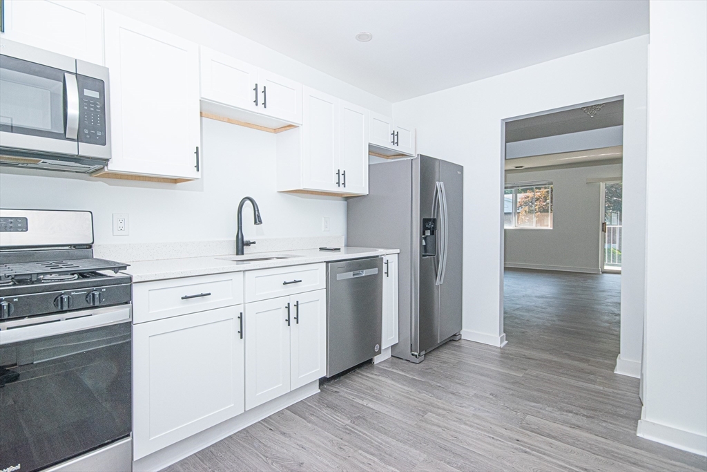 41 Bayberry Drive, Unit 4 Sharon, MA 02067 - Photo 15 of 27 a kitchen with cabinets appliances and wooden floor