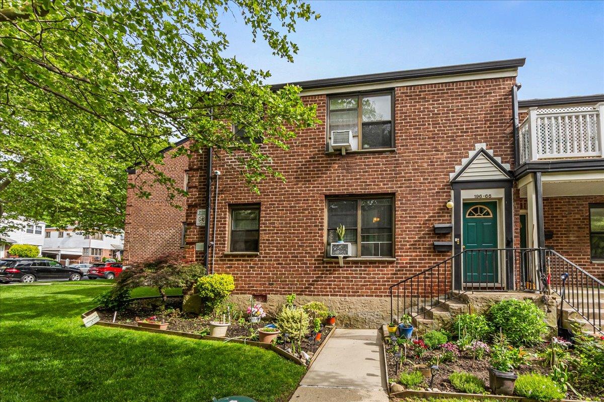 a front view of a house with a garden and plants