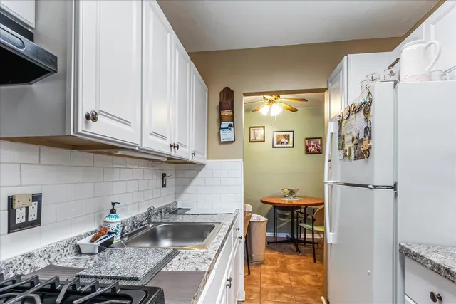 a kitchen with stainless steel appliances granite countertop a refrigerator sink and stove