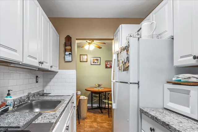 a kitchen with stainless steel appliances granite countertop a refrigerator and a sink