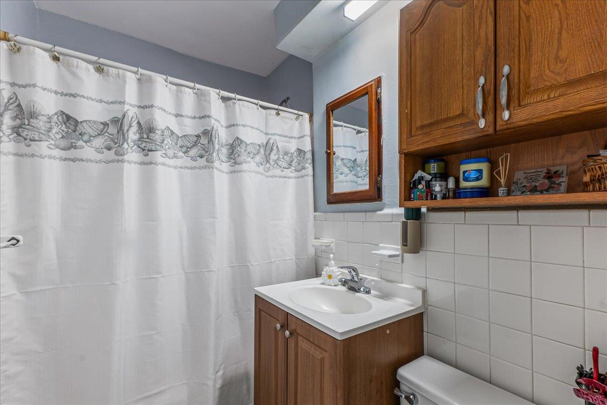 196-66 67th Avenue, Unit 1 Queens, NY 11365 - Photo 15 of 19 a bathroom with a sink a toilet and shower curtain