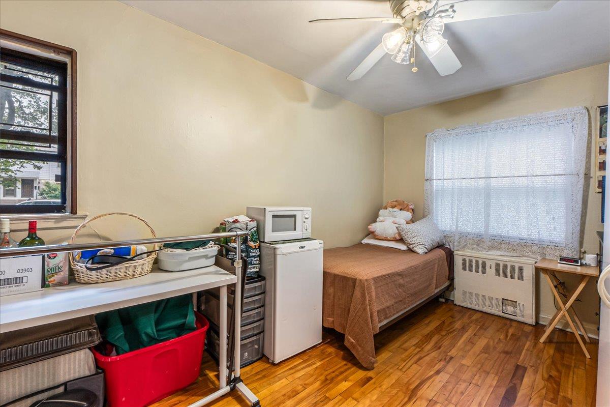 196-66 67th Avenue, Unit 1 Queens, NY 11365 - Photo 16 of 19 a bedroom with a bed and a chandelier
