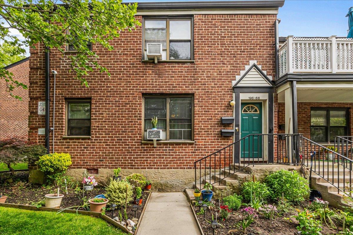 196-66 67th Avenue, Unit 1 Queens, NY 11365 - Photo 2 of 19 a view of a brick house with a flower garden