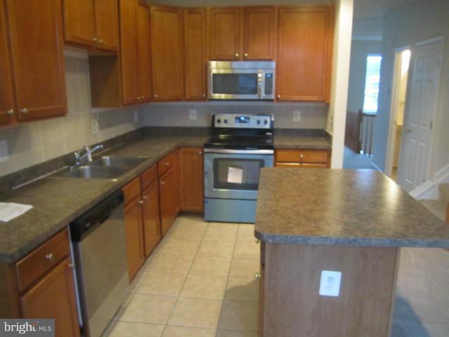 9613 Bird River Road Baltimore, MD 21220 - Photo 9 of 20 a kitchen with stainless steel appliances granite countertop a sink a stove microwave and cabinets