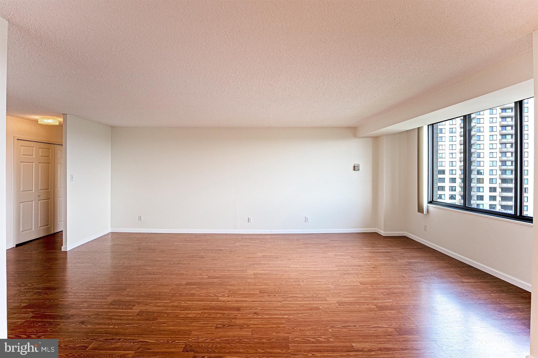 5225 Pooks Hill Road, Unit 721S Bethesda, MD 20814 - Photo 7 of 22 a view of an empty room with window and wooden floor