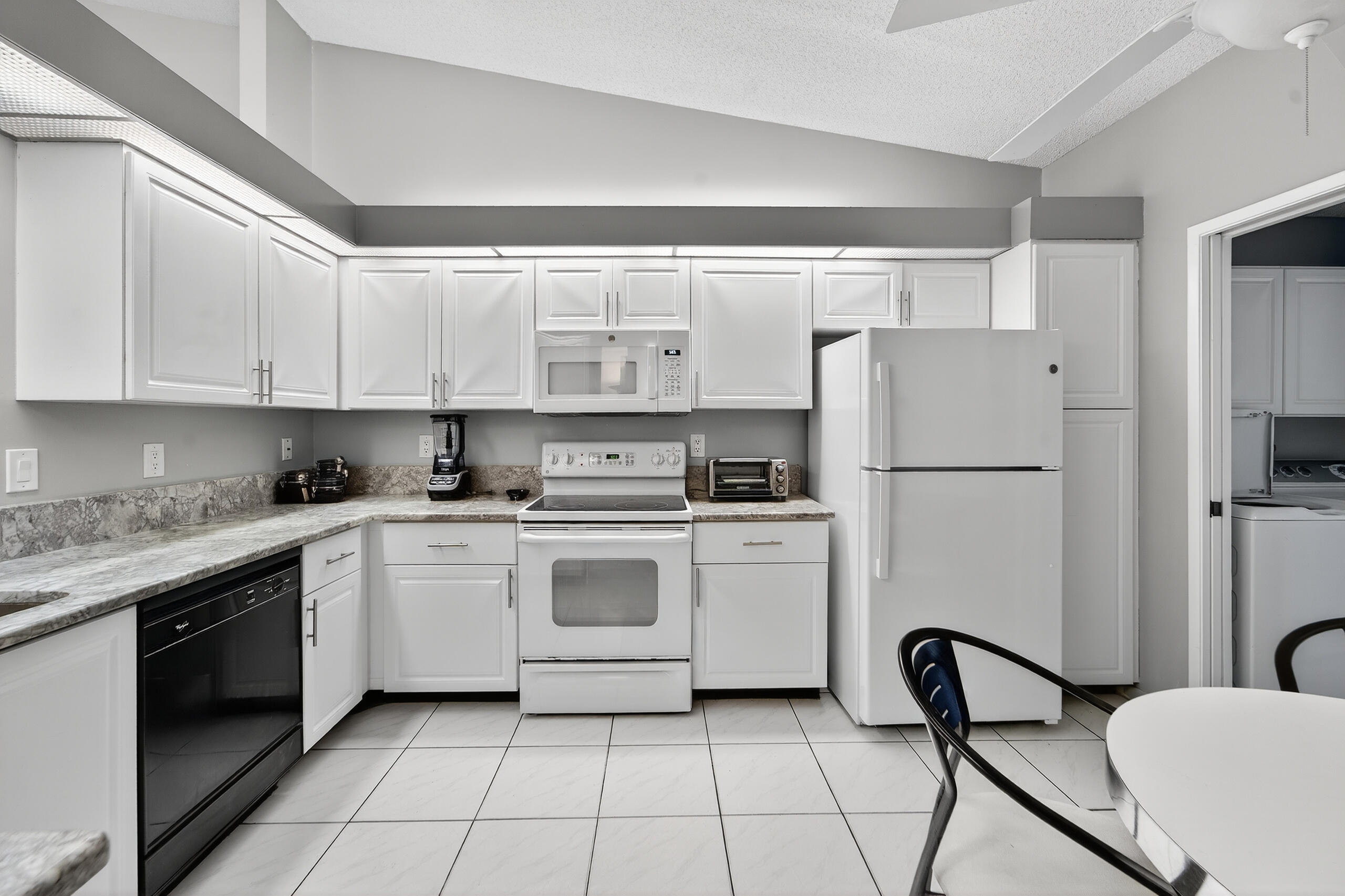 a kitchen with a refrigerator a stove a sink and white cabinets