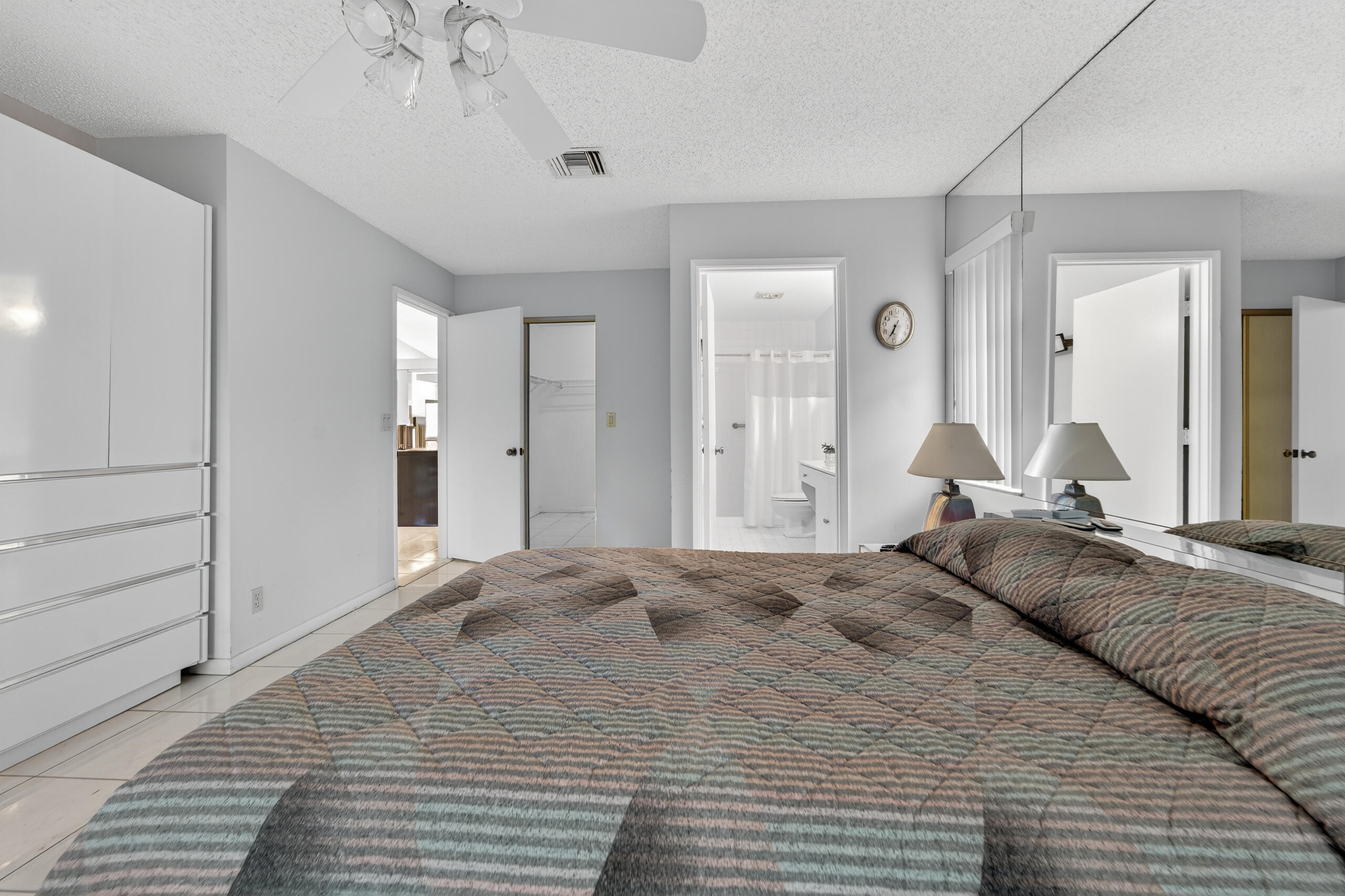 6065 Sunny Manor Court Delray Beach, FL 33484 - Photo 18 of 58 a large bedroom with a large bed and chandelier