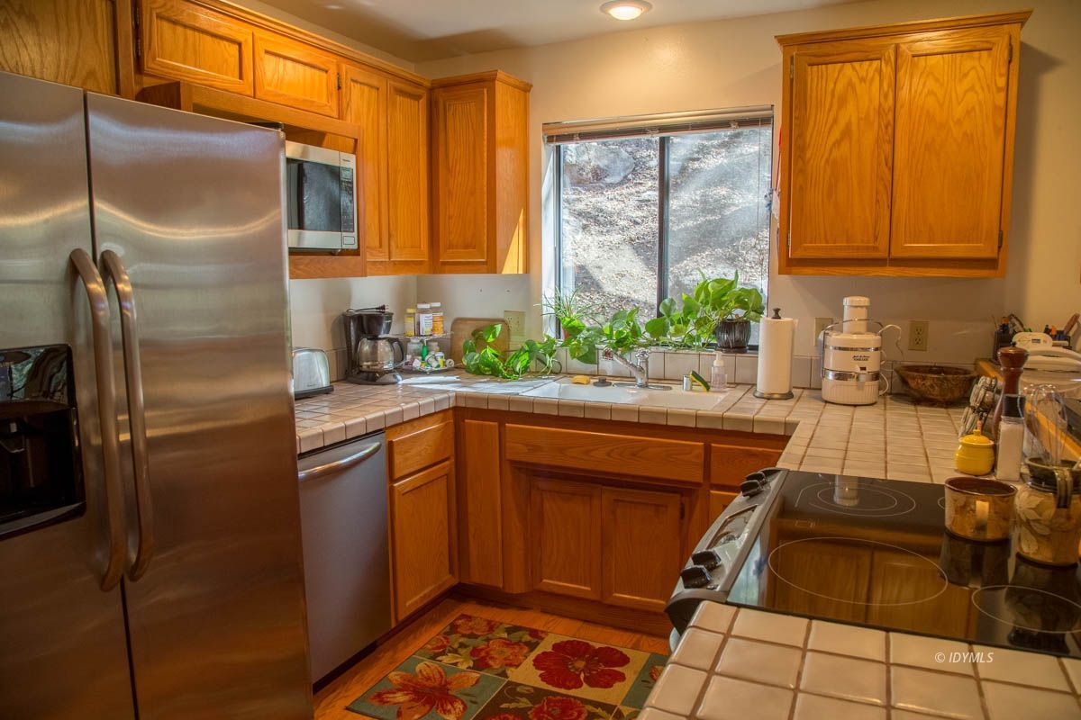 26540 Saunders Meadow Road Idyllwild, CA 92549 - Photo 12 of 34 a kitchen with stainless steel appliances granite countertop a refrigerator and a sink