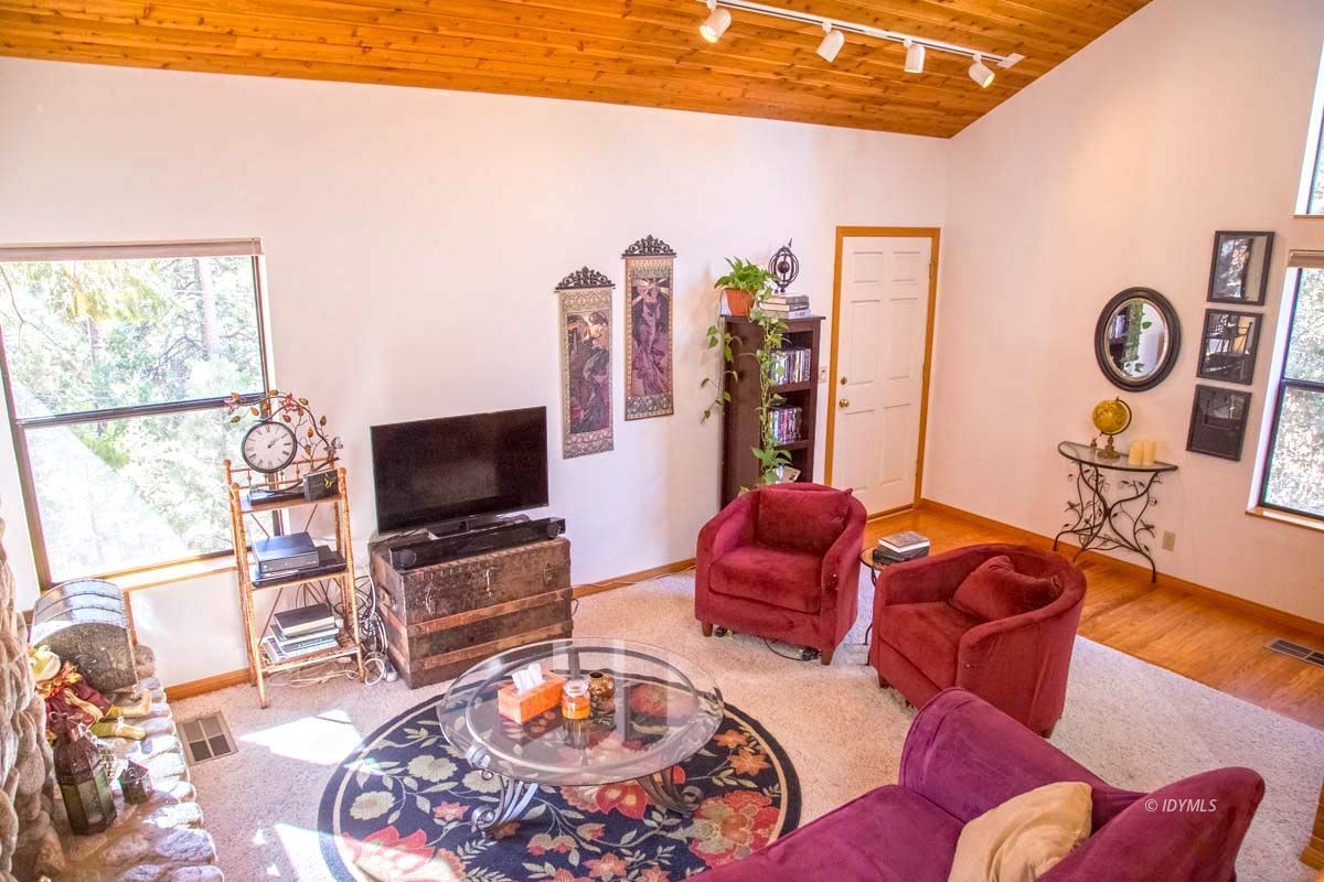 26540 Saunders Meadow Road Idyllwild, CA 92549 - Photo 5 of 34 a living room with furniture a flat screen tv and a large window