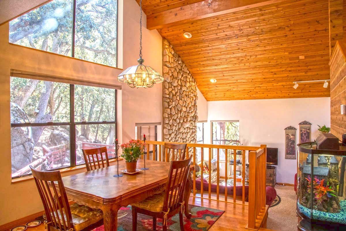 26540 Saunders Meadow Road Idyllwild, CA 92549 - Photo 9 of 34 a dining room with furniture and a floor to ceiling window