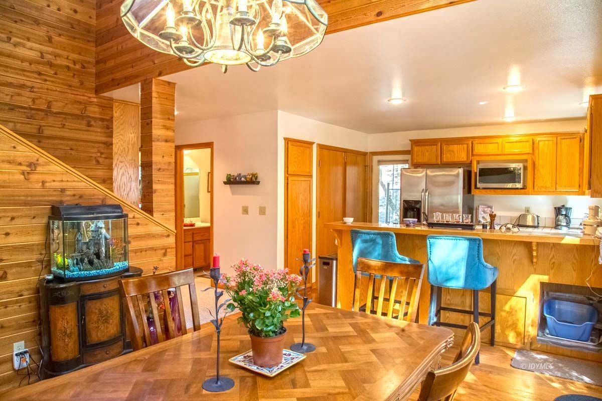 26540 Saunders Meadow Road Idyllwild, CA 92549 - Photo 10 of 34 a view of a dining room with furniture a chandelier and wooden floor