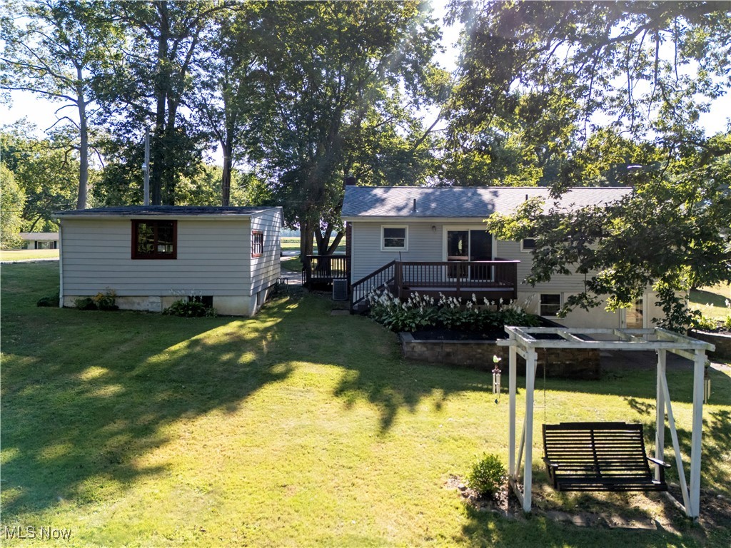 View of grassy yard featuring a deck
