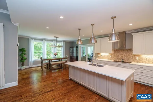 a kitchen with kitchen island granite countertop a stove a sink a center island and cabinets