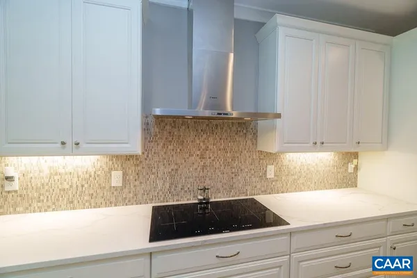 a kitchen with granite countertop white cabinets and stainless steel appliances