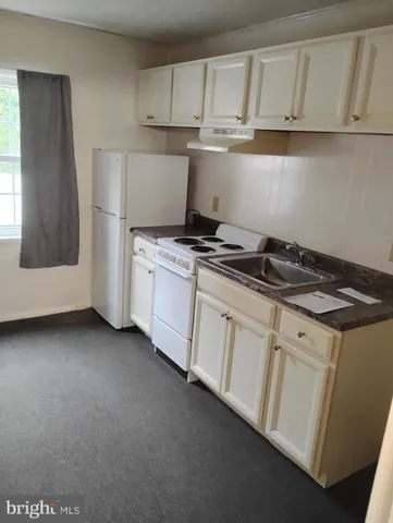a kitchen with granite countertop white cabinets and white appliances