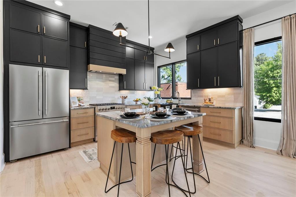 a kitchen with a refrigerator a stove a sink and a dining table with wooden floor