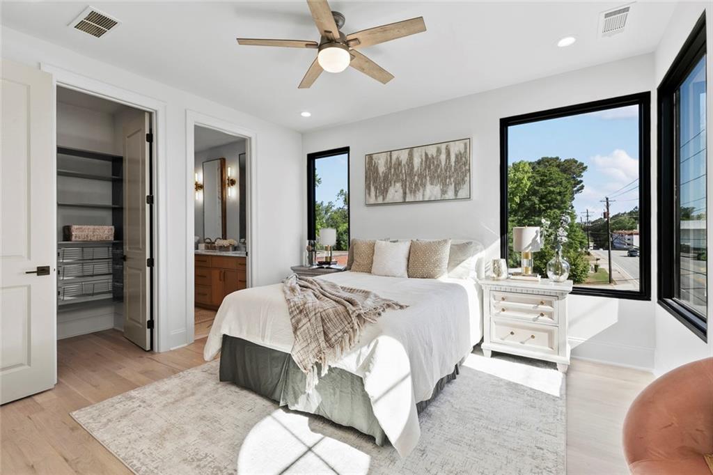 1962 8th Street, Unit 5 Chamblee, GA 30341 - Photo 35 of 57 a spacious bedroom with a large bed and a chandelier