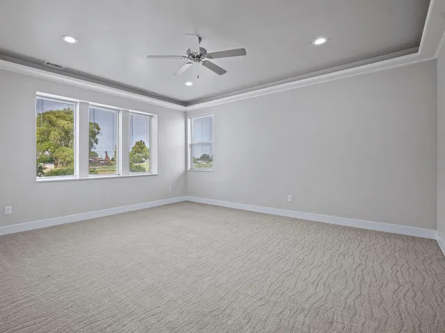 an empty room with windows and ceiling fan view