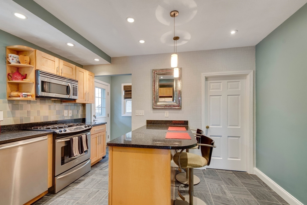 2 Deane Avenue Winthrop, MA 02152 - Photo 10 of 42 a kitchen with stainless steel appliances granite countertop a stove top oven a sink a dining table and chairs with wooden floor
