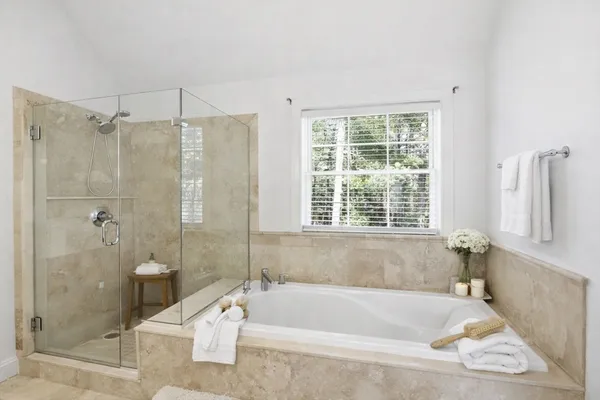 a bath tub sitting next to a white bath tub and a shower