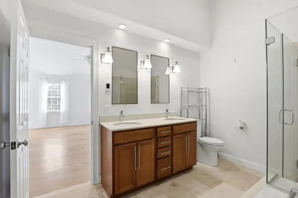 a spacious bathroom with a granite countertop sink a toilet and a mirror